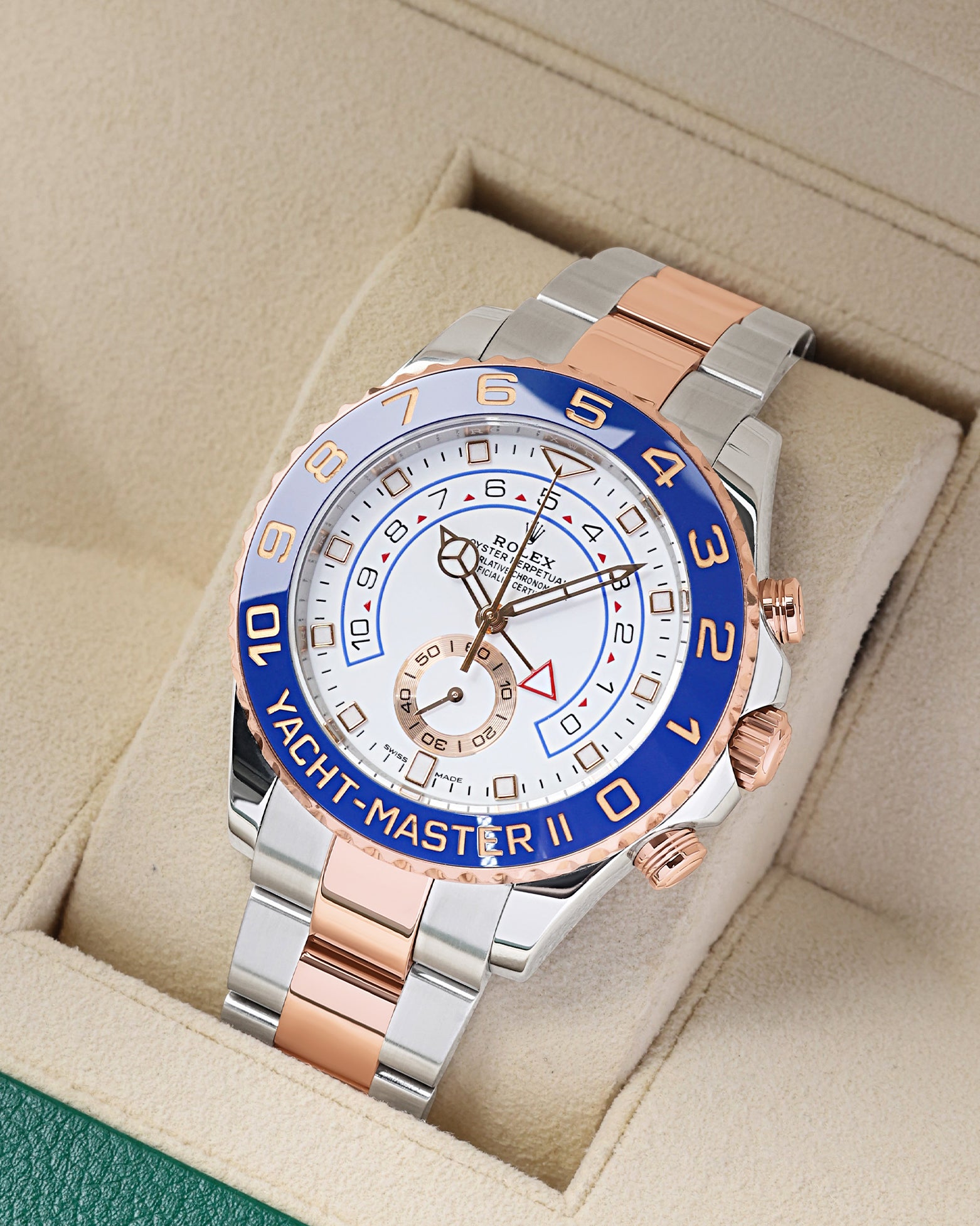 Angled front view of an Everose gold and stainless steel Rolex Yacht-Master II 44mm regatta chronograph inside its green presentation box in Dallas