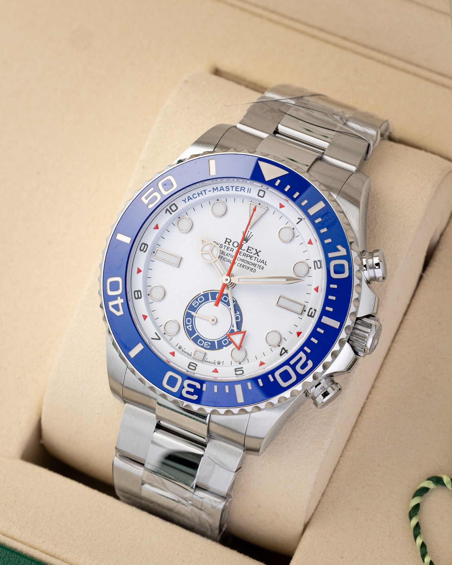 Angled shot of an unworn 2026 Rolex Yacht-Master II 44mm reference 126680 showing the blue Ring Command bezel and factory plastic stickers on the Oyster bracelet.