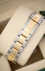 rear view snapshot focusing on the yellow gold and steel three-link Oyster bracelet and its folding Oysterlock safety clasp closure