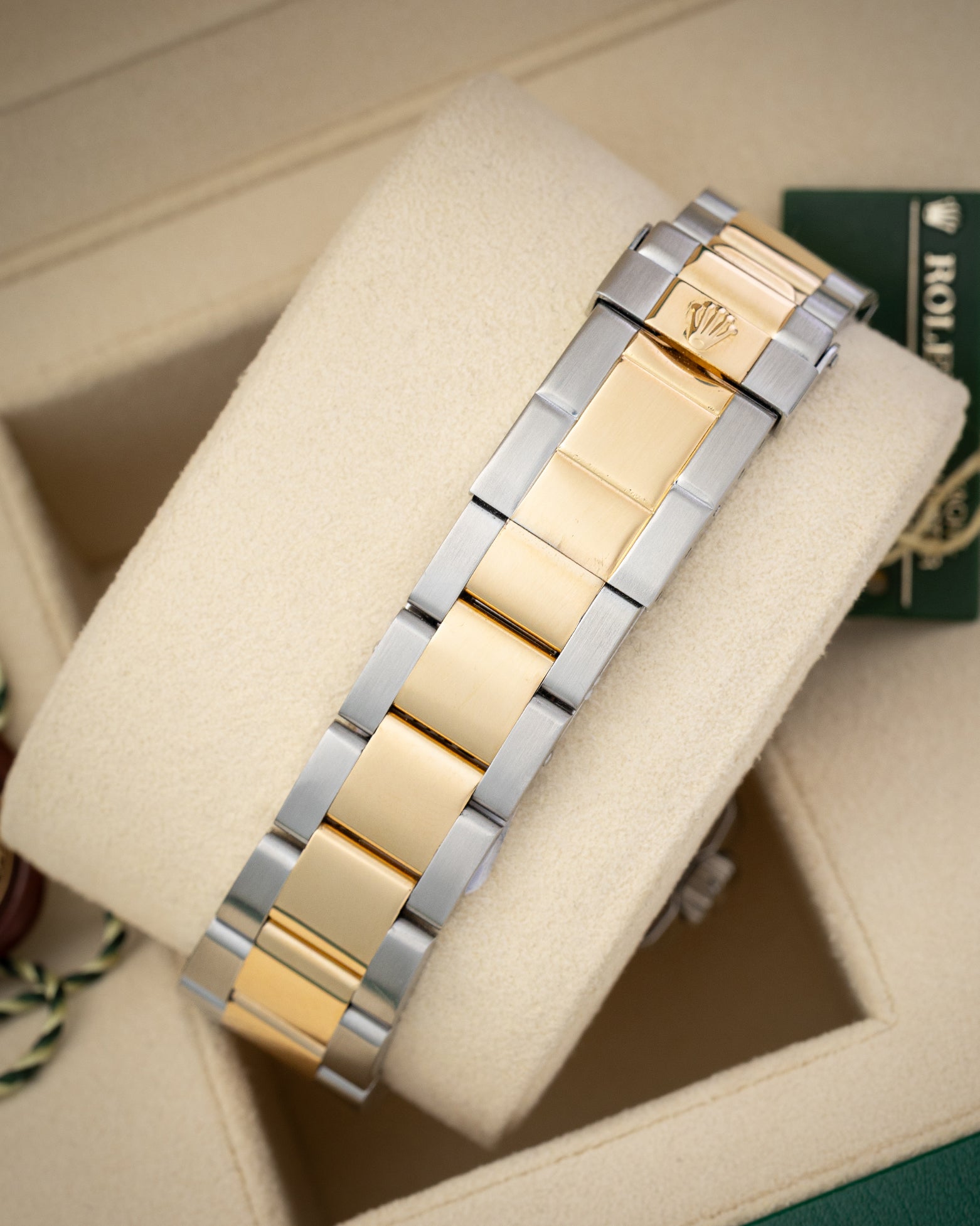 rear view snapshot focusing on the yellow gold and steel three-link Oyster bracelet and its folding Oysterlock safety clasp closure