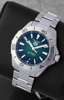 Angled collector view of a 40mm TAG Heuer Aquaracer Professional 200 highlighting the gradient green face, white luminescent index markers, and steel link bracelet