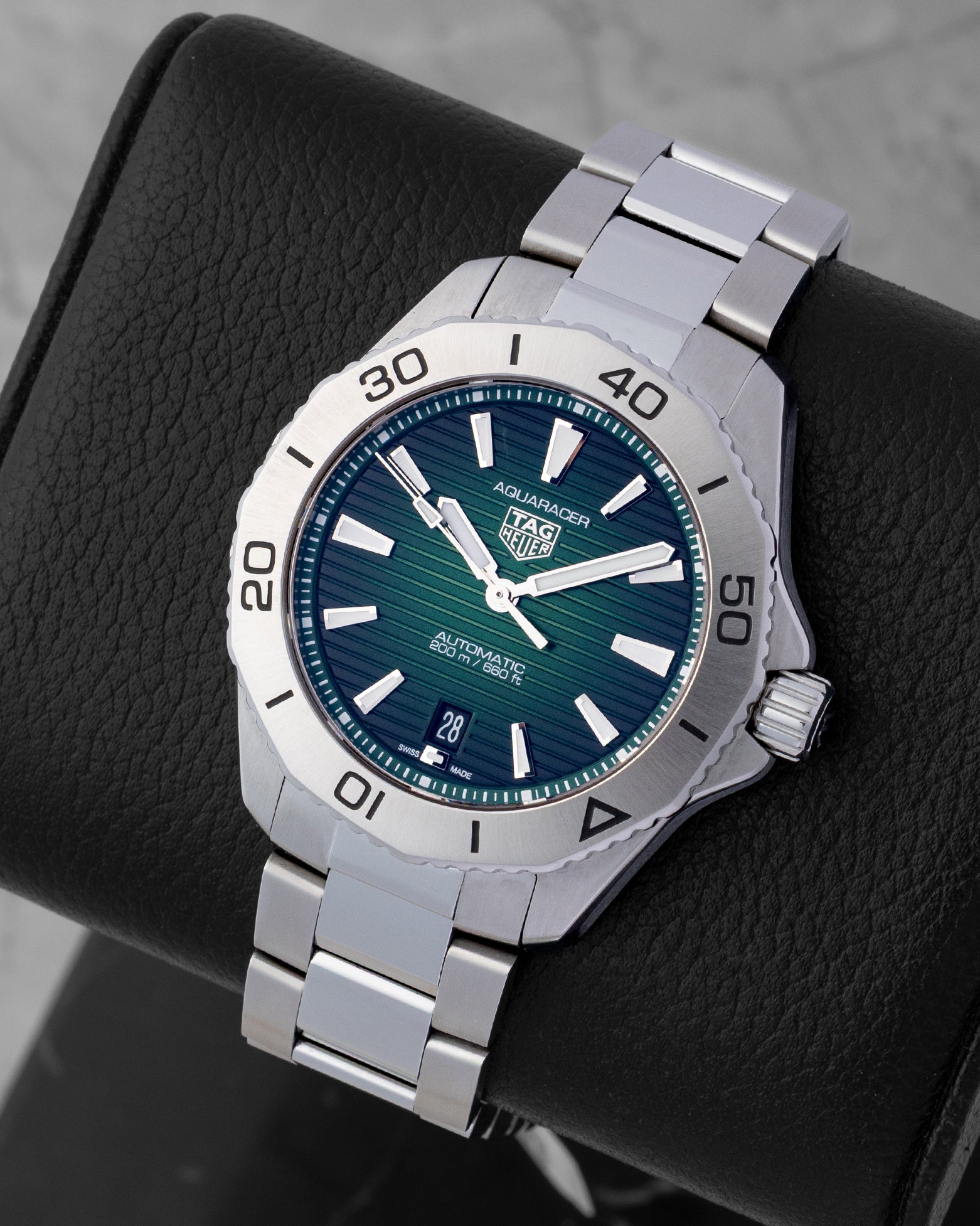 Angled collector view of a 40mm TAG Heuer Aquaracer Professional 200 highlighting the gradient green face, white luminescent index markers, and steel link bracelet