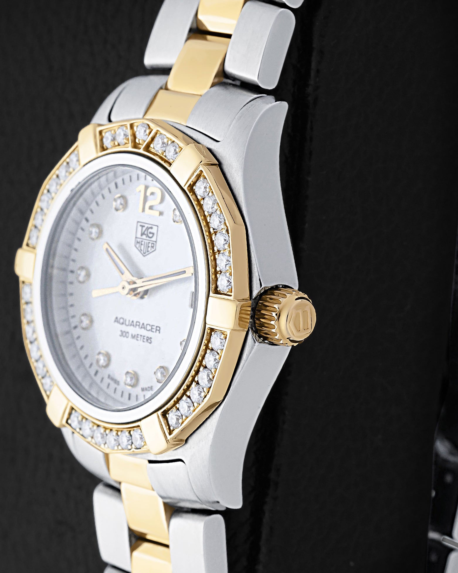 Two-tone case profile view showcasing the 18k yellow gold screw-down winding crown and diamond-set bezel profile on a 27mm ladies TAG Heuer Aquaracer