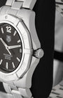 Close-up right profile view of the watch head highlighting the heavy-duty fluted screw-down winding crown nestled securely between smooth integrated steel case shoulders