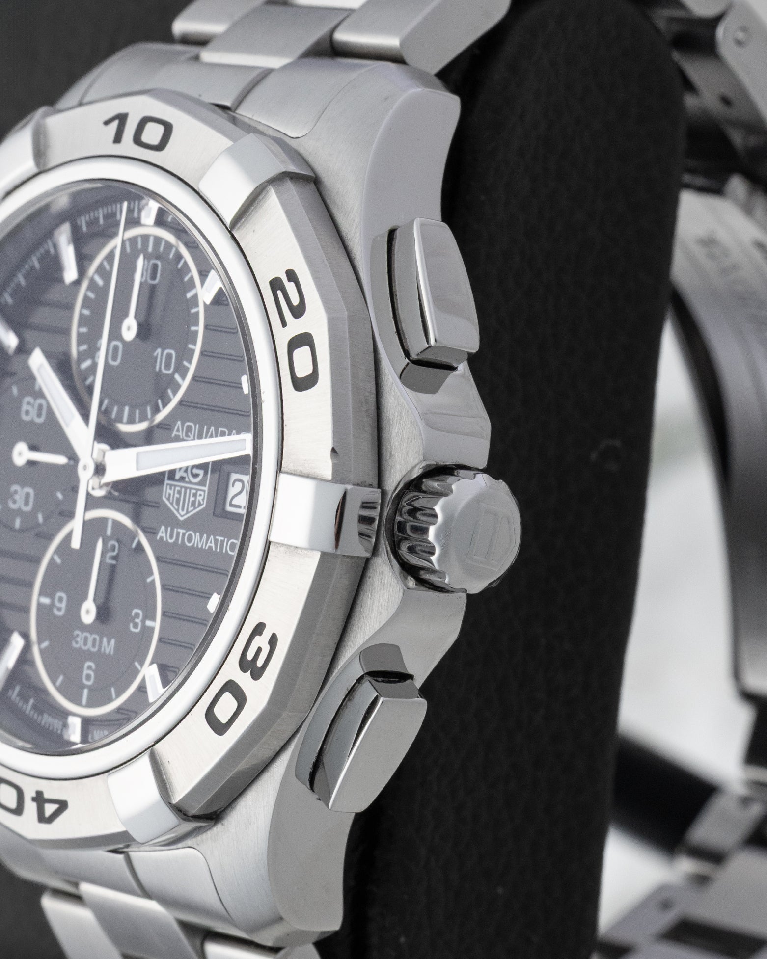 Right side profile view highlighting the screw-down crown, chronograph pushers, and engraved steel bezel on a TAG Heuer Aquaracer CAP2110