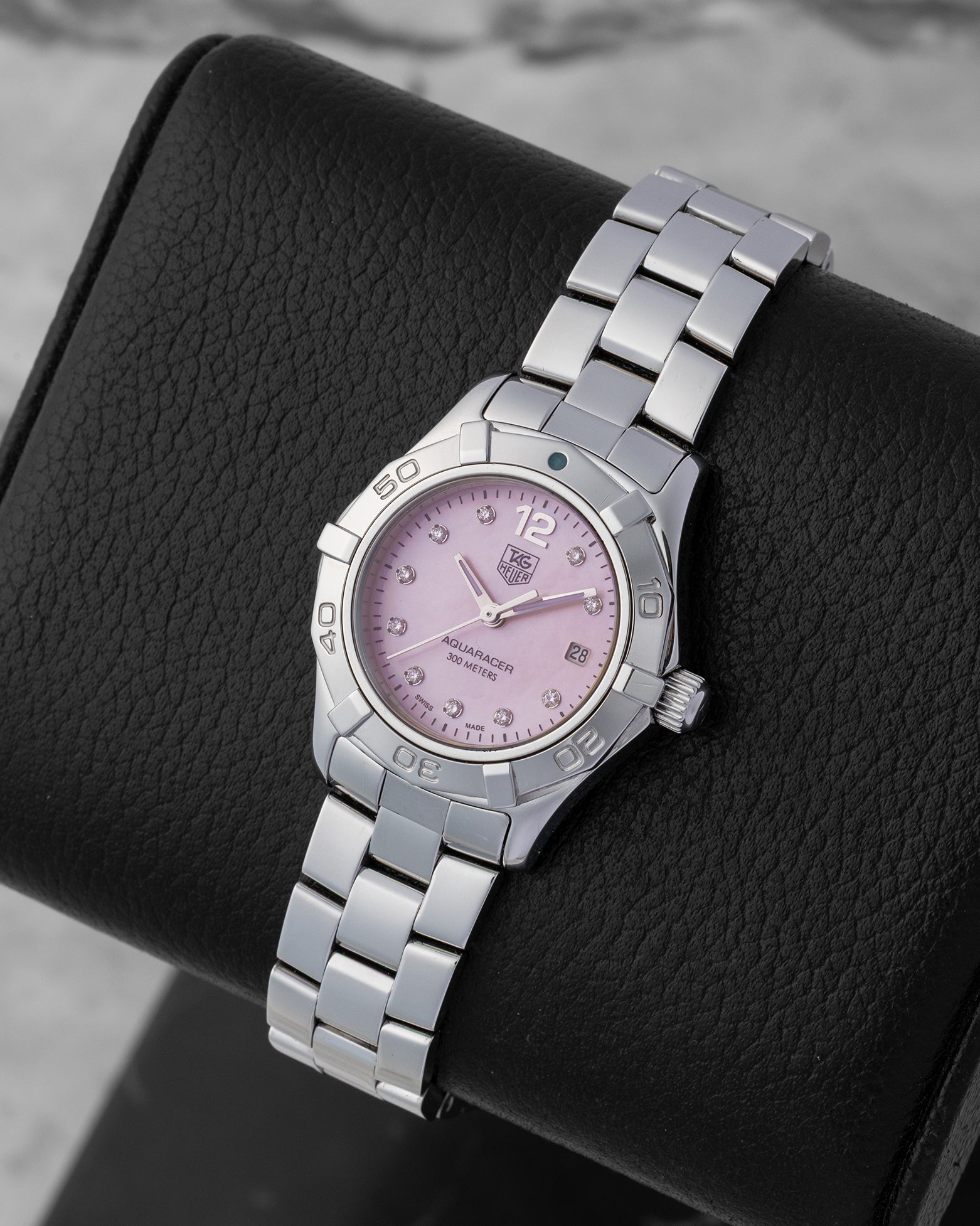Angled collector view of a ladies 27mm TAG Heuer Aquaracer ref WAF141A highlighting the iridescence of the baby pink shell dial under sapphire crystal