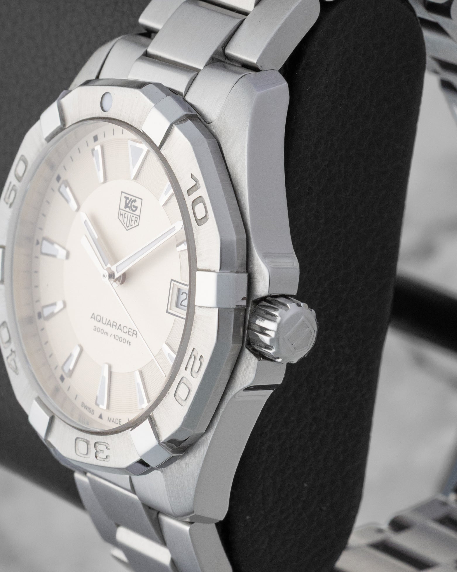 Right side profile view highlighting the screw-down crown and engraved steel unidirectional rotating bezel on a TAG Heuer Aquaracer WAY1111