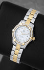 angled profile view of a lady's two-tone TAG Heuer Aquaracer reference WAF1450 showcasing factory diamond hour markers and a diamond-encrusted bezel
