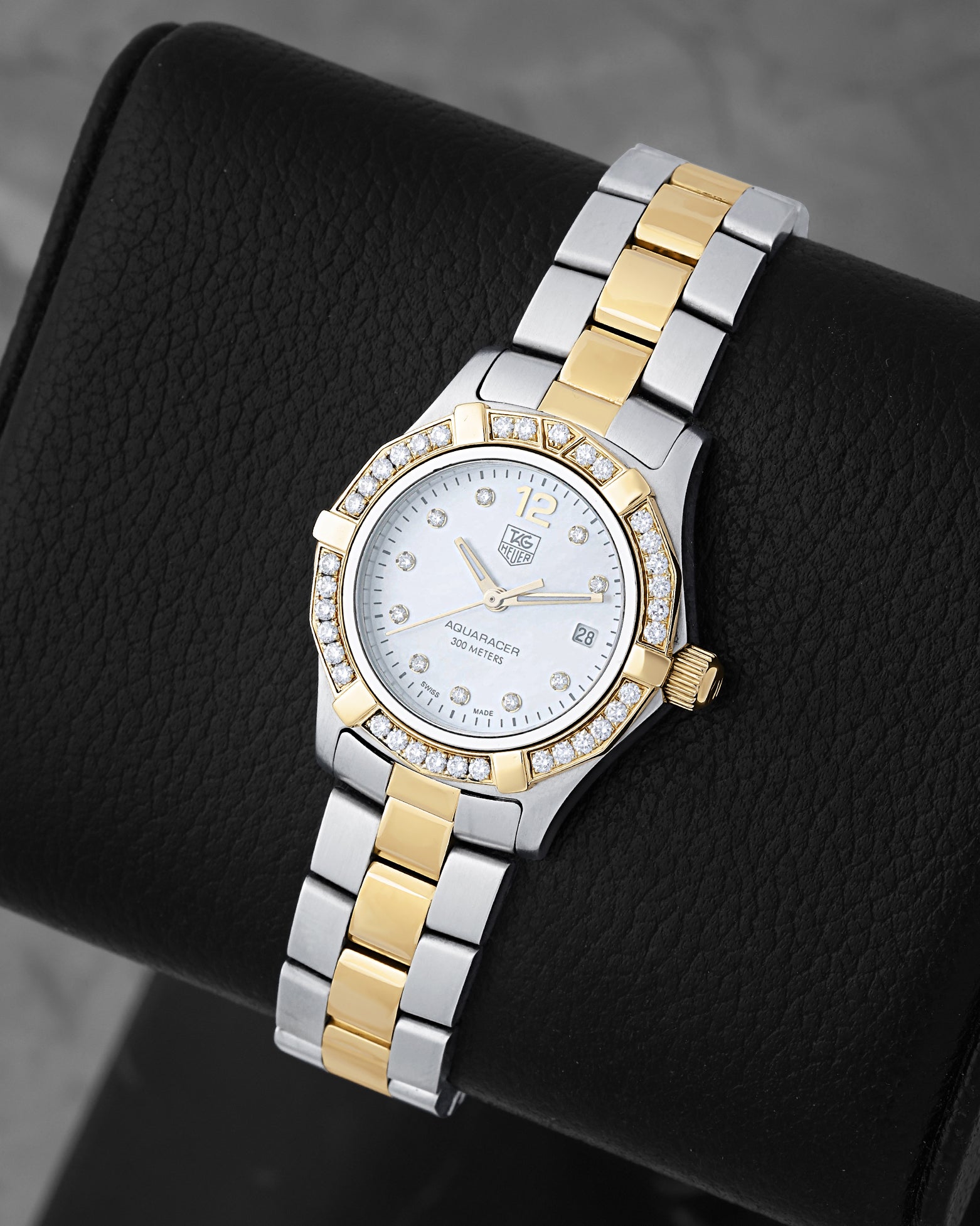 angled profile view of a lady's two-tone TAG Heuer Aquaracer reference WAF1450 showcasing factory diamond hour markers and a diamond-encrusted bezel