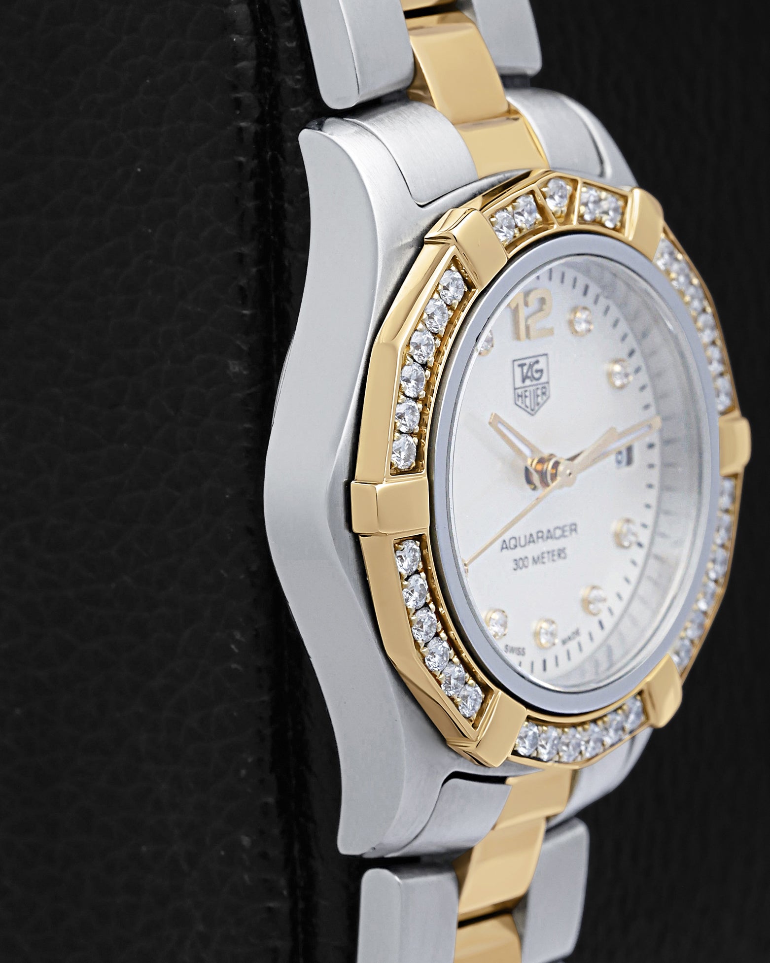 stainless steel left-side case profile view of a pre-owned 27mm ladies TAG Heuer Aquaracer sports watch resting on a presentation block