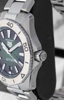 Macro profile showing the ergonomic 12-faceted brushed steel rotating bezel and the heavy-duty screw-down crown with integrated guard profile