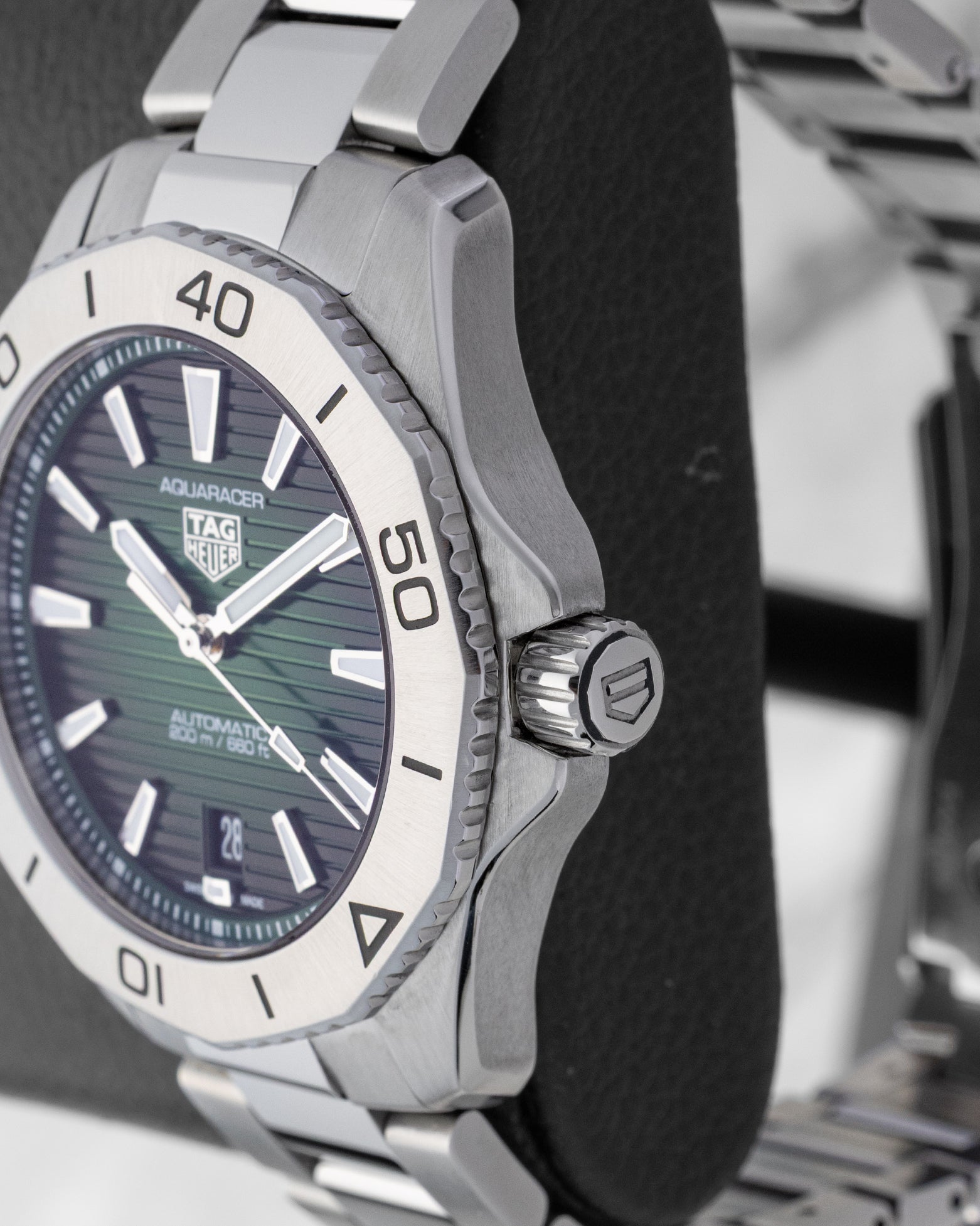 Macro profile showing the ergonomic 12-faceted brushed steel rotating bezel and the heavy-duty screw-down crown with integrated guard profile
