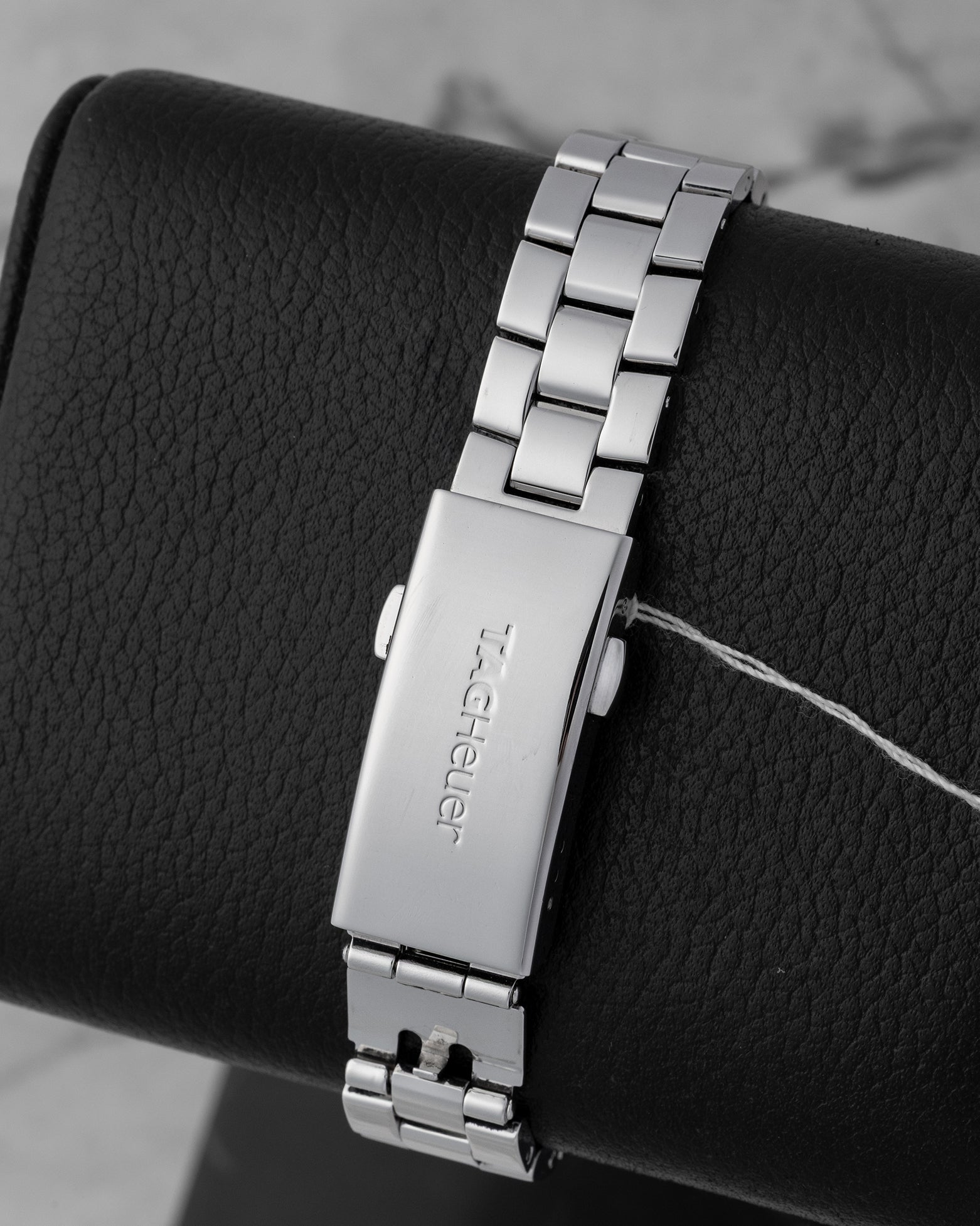 Rear view of the brushed three-link BA0824 steel bracelet secured with a folding deployment safety clasp stamped with the signature TAG Heuer brand lettering