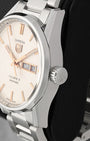 Close-up right profile view of the watch head focusing on the crisp, high-polished bezel edge and the clean fluted push-pull winding crown signed with the TAG Heuer shield logo