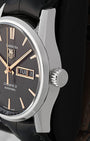 A close-up right-side profile view of the Carrera case focusing on the crisp day-date calendar window frame and the robust fluted stainless steel push-pull winding crown