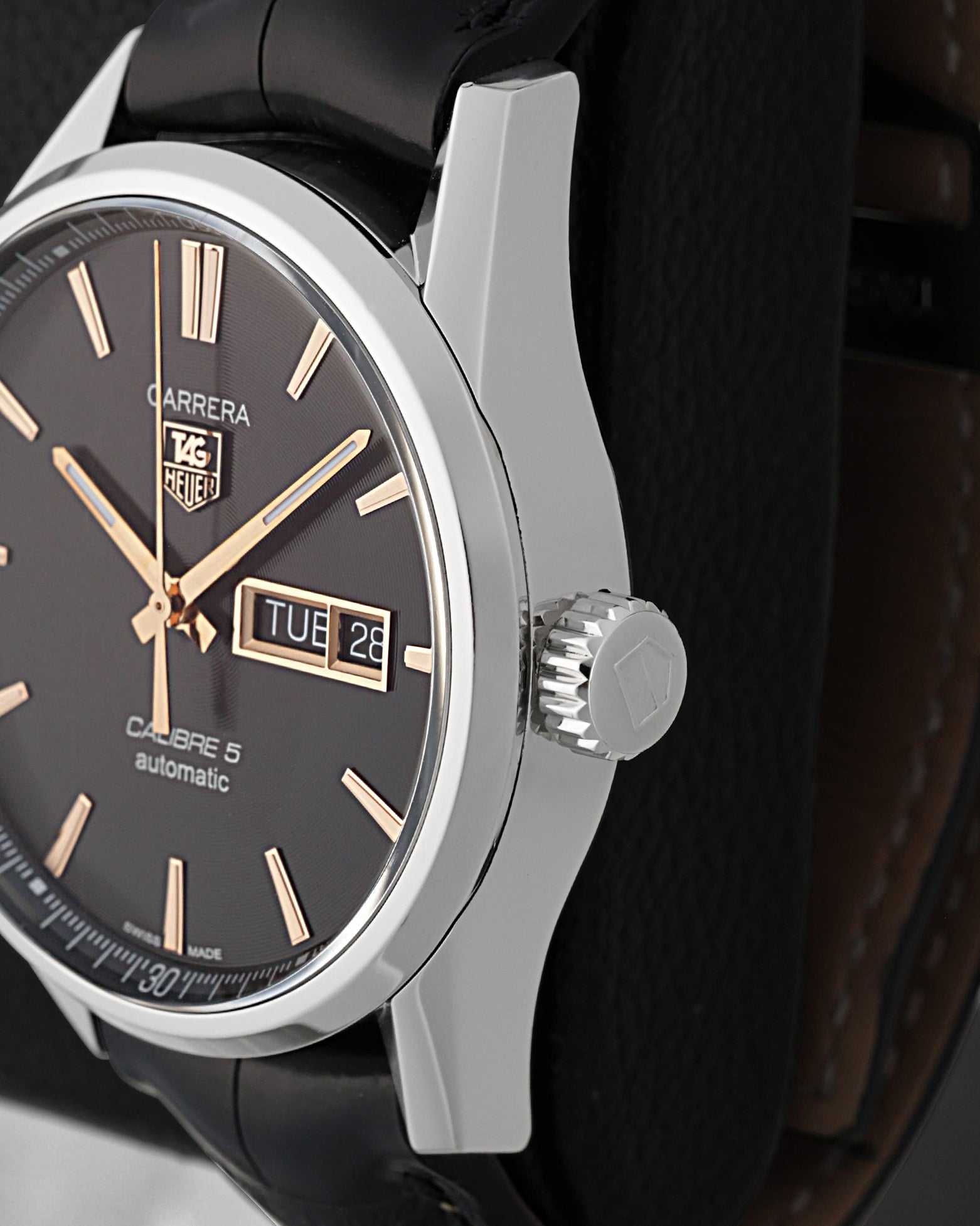 A close-up right-side profile view of the Carrera case focusing on the crisp day-date calendar window frame and the robust fluted stainless steel push-pull winding crown