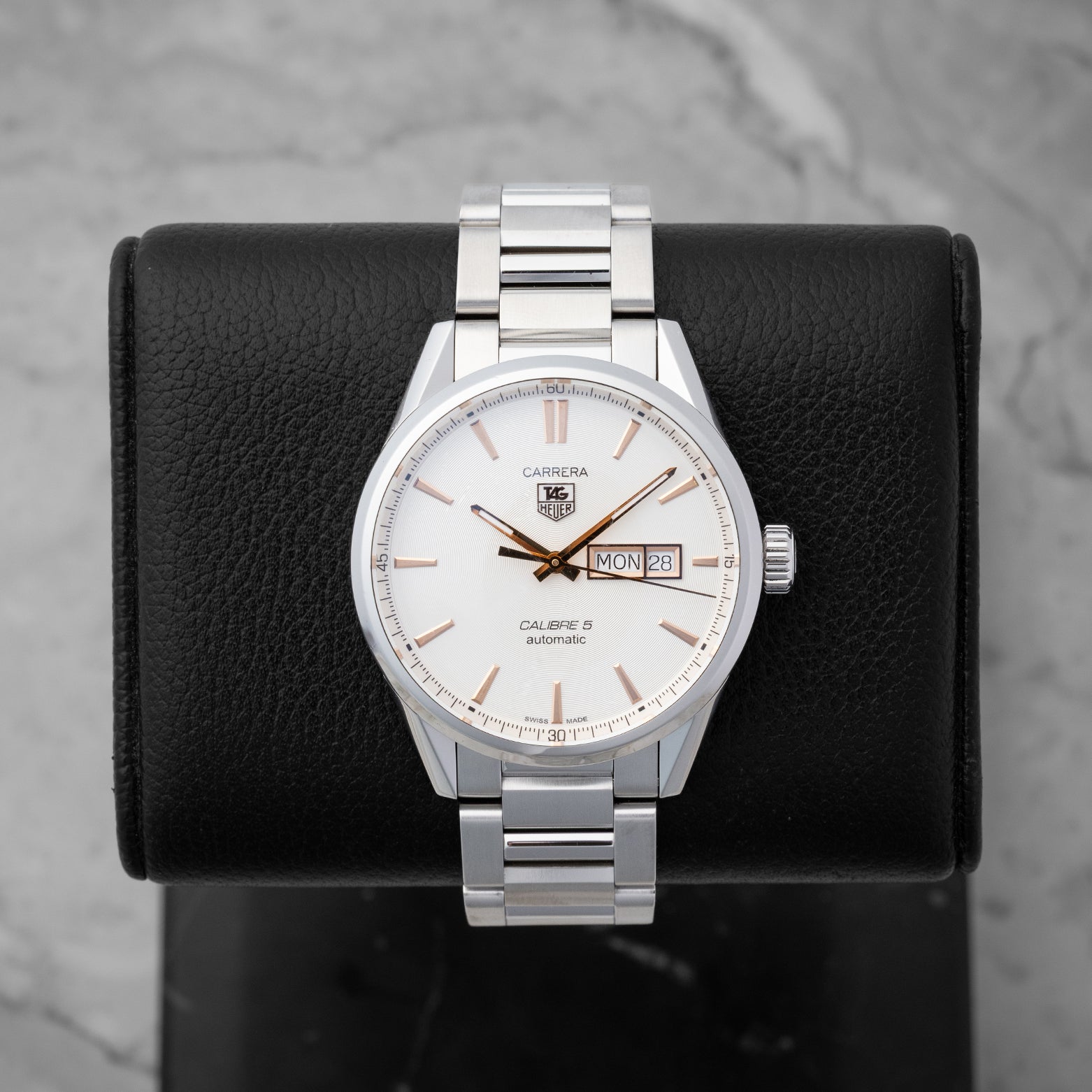 TAG Heuer Carrera Calibre 5 Day-Date watch WAR201D featuring a silver dial with rose gold accents on a black display stand