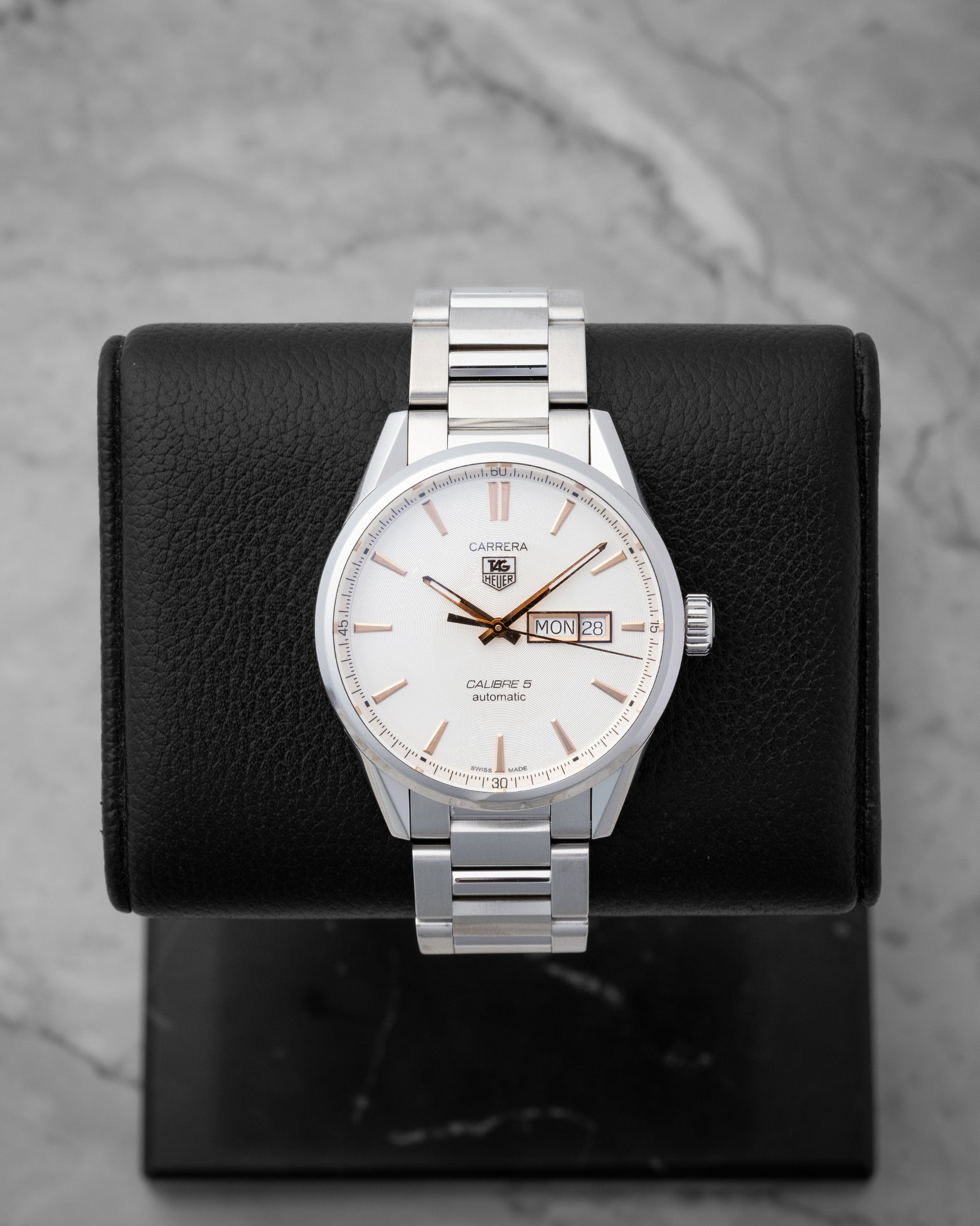 TAG Heuer Carrera Calibre 5 Day-Date watch WAR201D featuring a silver dial with rose gold accents on a black display stand