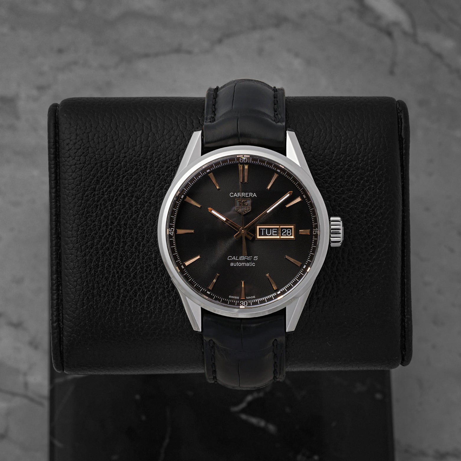 A TAG Heuer Carrera Calibre 5 Day-Date reference WAR201C featuring a black azurage dial with rose gold-plated accents on a black alligator leather strap at Noah's Fine Watches & Jewelry in Dallas
