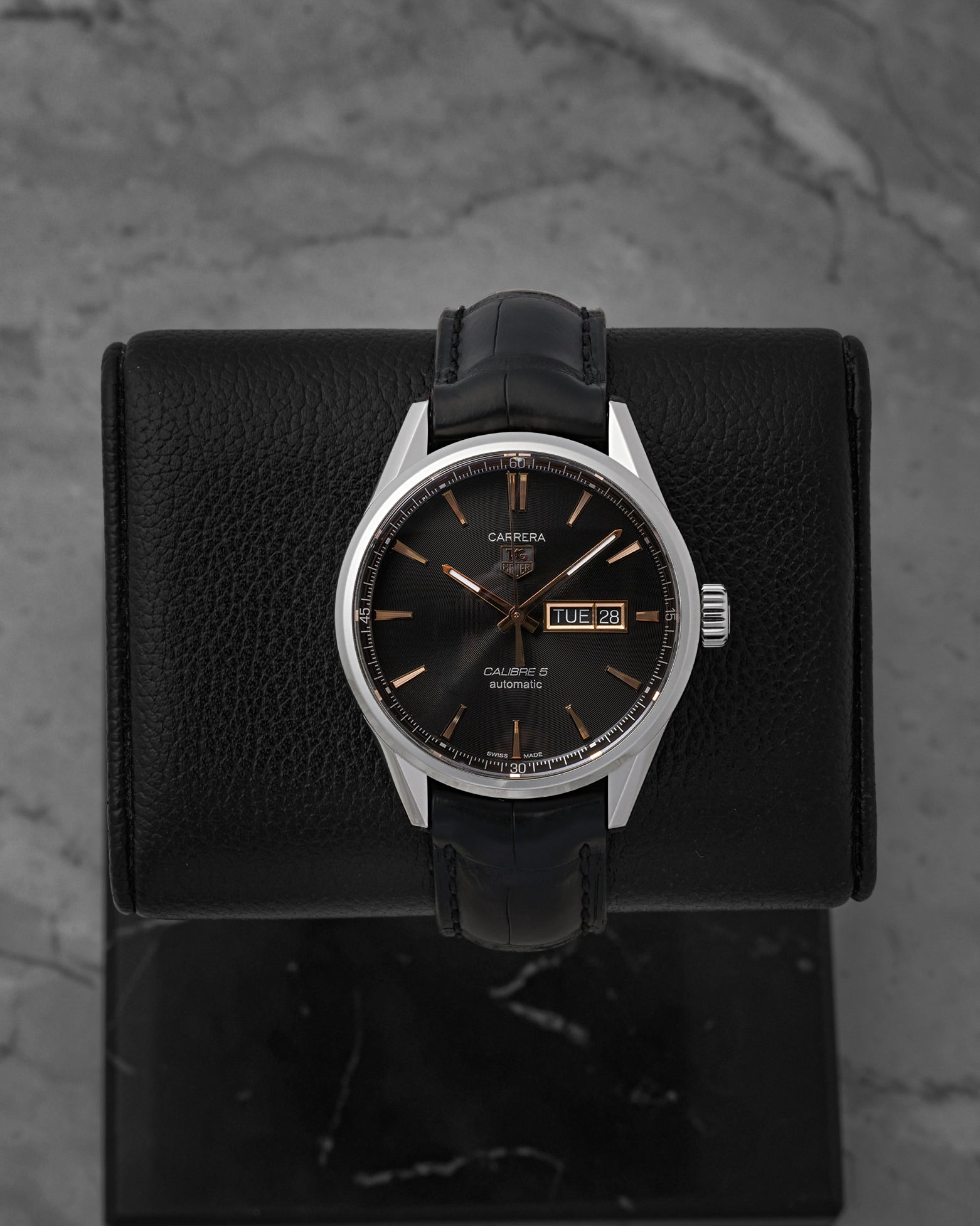 A TAG Heuer Carrera Calibre 5 Day-Date reference WAR201C featuring a black azurage dial with rose gold-plated accents on a black alligator leather strap at Noah's Fine Watches & Jewelry in Dallas