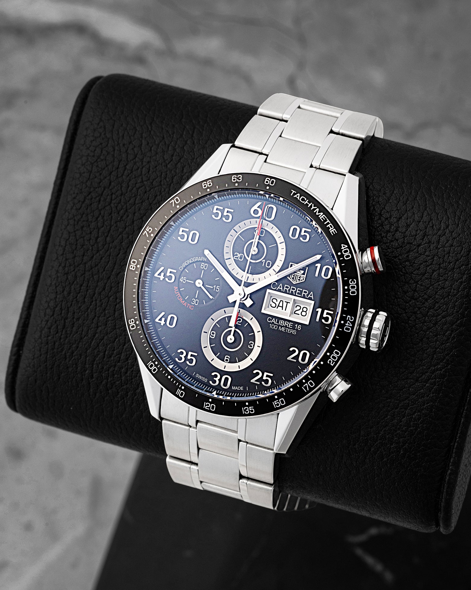 Angled front view of pre owned TAG Heuer Carrera CV2A10.BA0796 featuring a black dial, Arabic numerals, day-date display, and tachymeter bezel