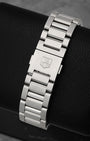 A rear view of the three-row stainless steel H-link metal watch band focusing on the secure push-button folding deployment clasp engraved with the block brand crest logo