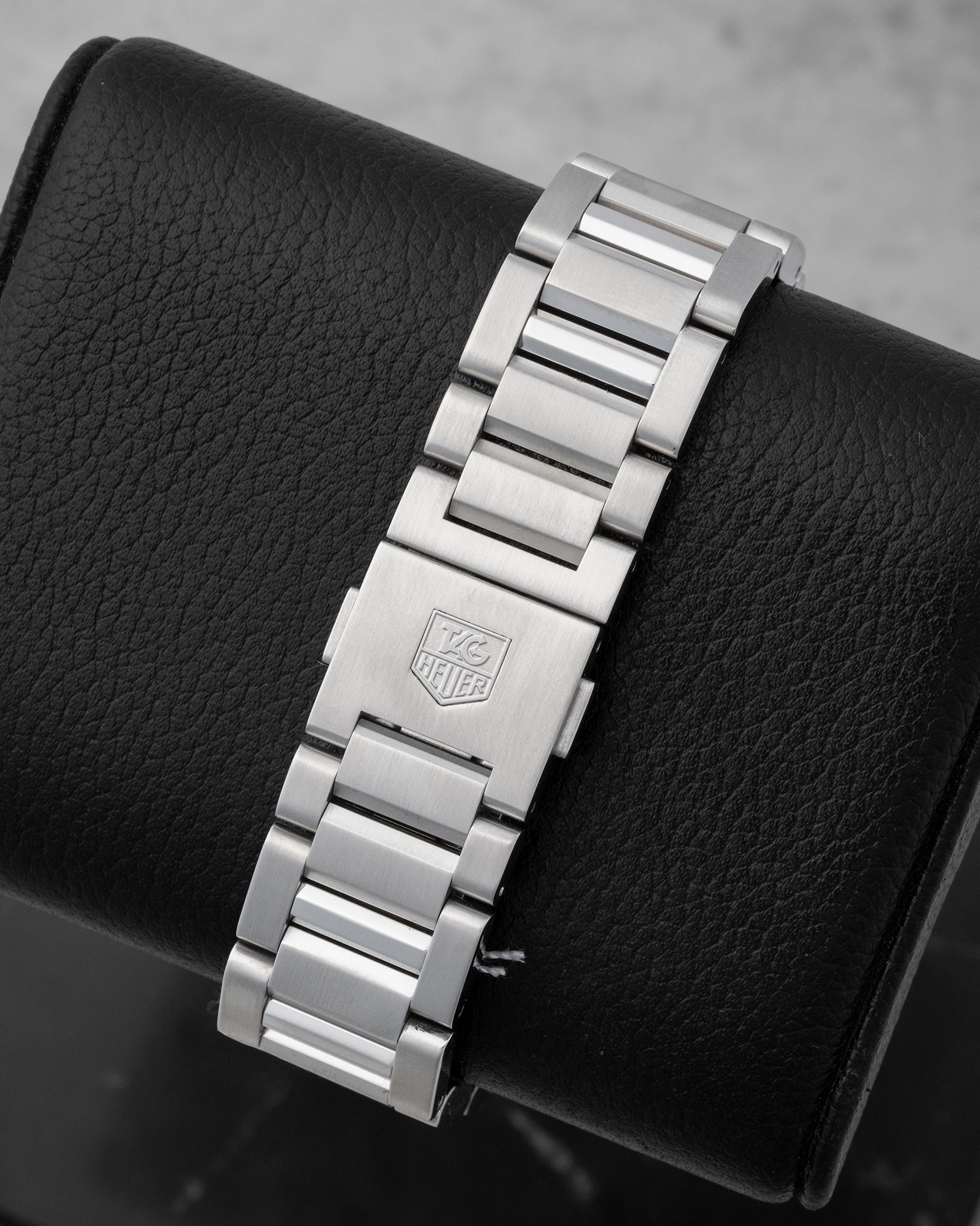 Rear studio view of the stainless steel H-link bracelet and folding clasp with the engraved TAG Heuer shield logo