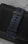 Rear studio view of the textured black rubber strap and matching black DLC coated stainless steel tang buckle closure