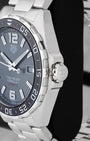 Side profile view of the stainless steel case showing the black ceramic notched bezel, red-accented crown collar, and signed crown