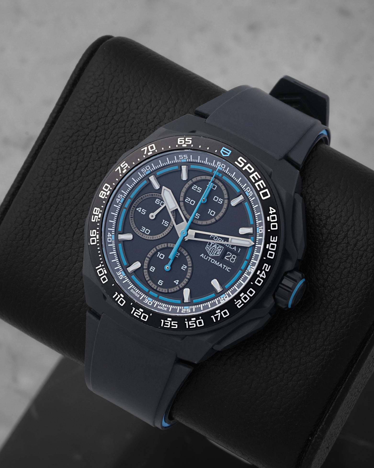 An angled studio profile shot of the black DLC titanium case and rubber strap of a TAG Heuer Formula 1 automatic watch