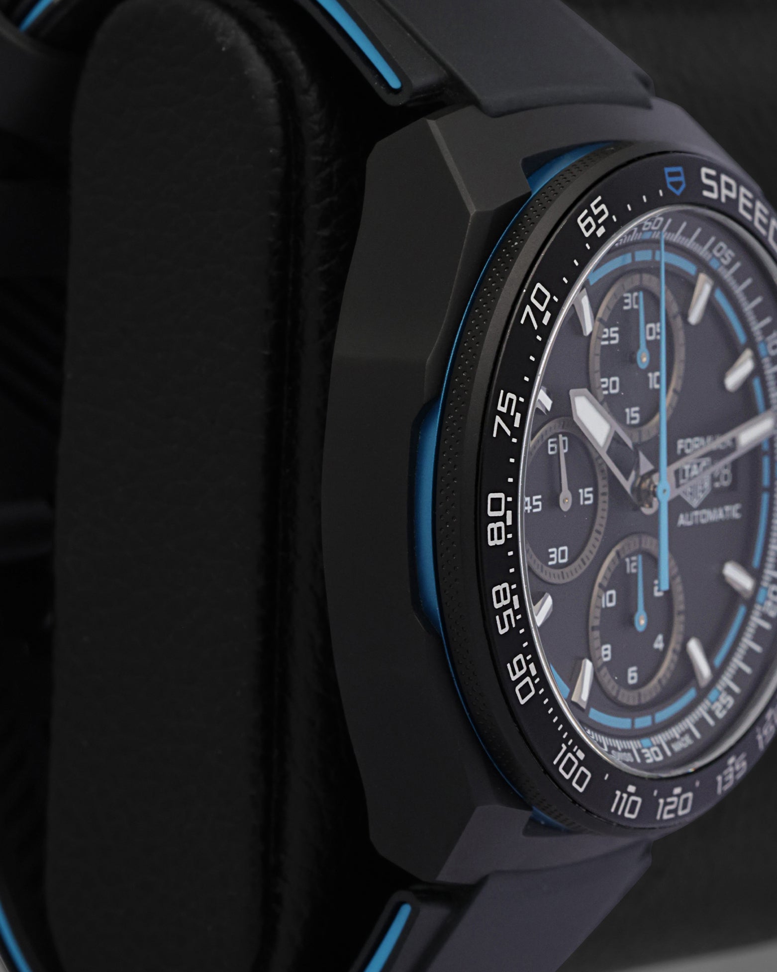 Side profile view of the non-crown side of a black DLC titanium TAG Heuer Formula 1 chronograph case on a display cushion