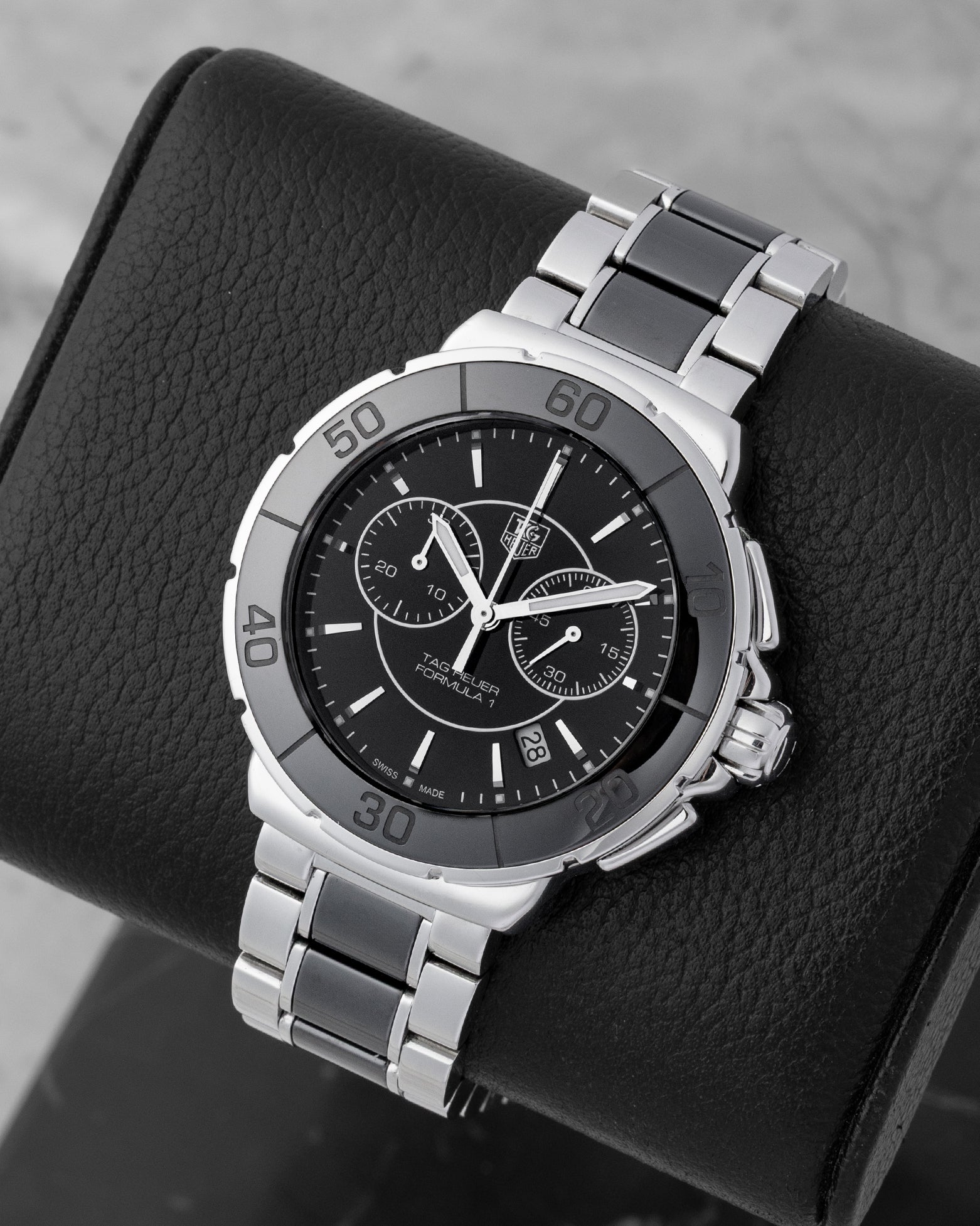 Angled collector view of a 41mm TAG Heuer Formula 1 luxury sports watch highlighting the striking contrast of polished stainless steel and deep black ceramic links
