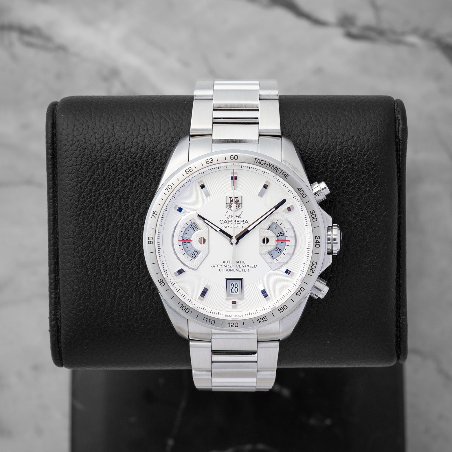 TAG Heuer Grand Carrera Calibre 17 RS Chronograph CAV511B featuring a white dial with dual rotating system disks on a black display stand