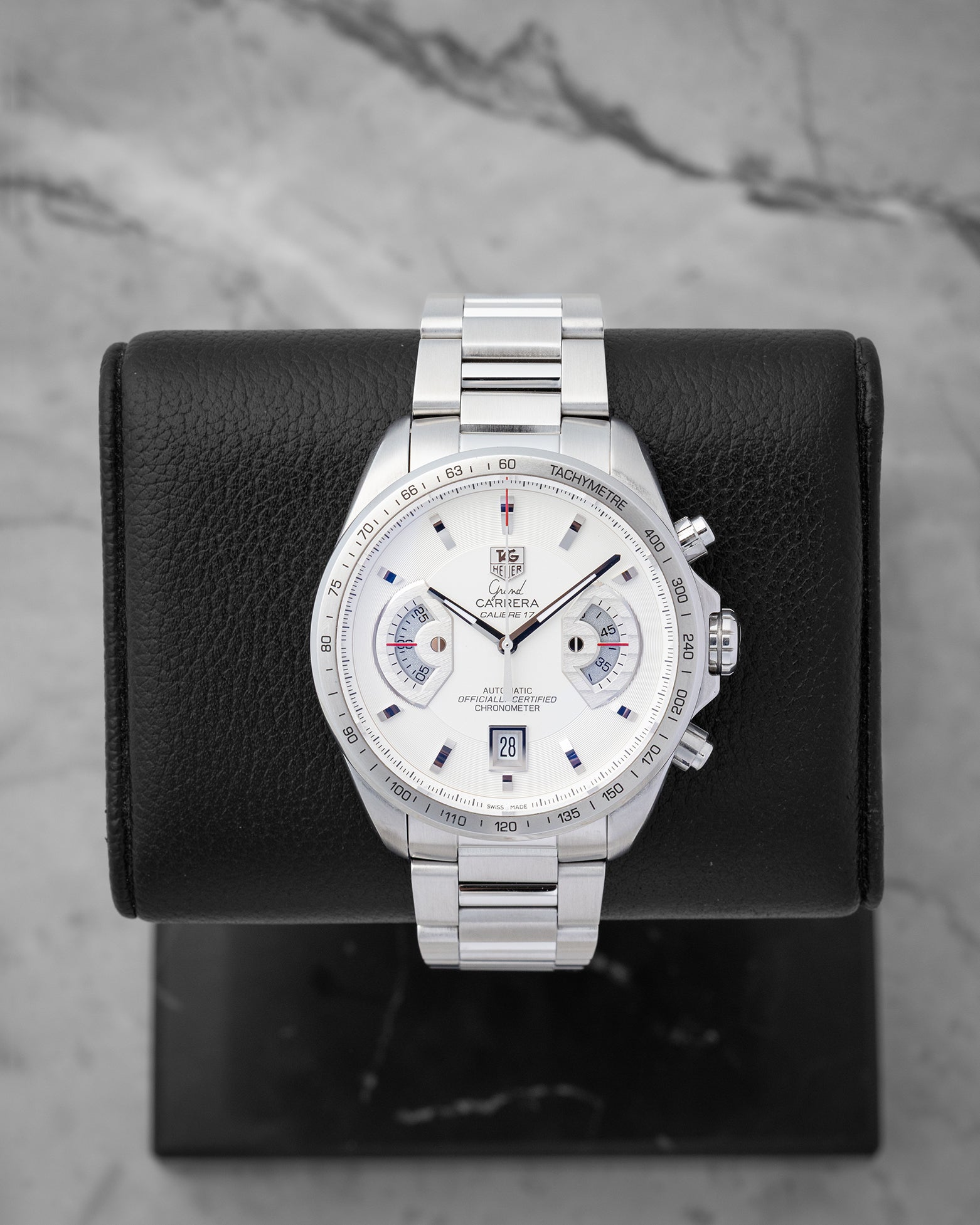 TAG Heuer Grand Carrera Calibre 17 RS Chronograph CAV511B featuring a white dial with dual rotating system disks on a black display stand
