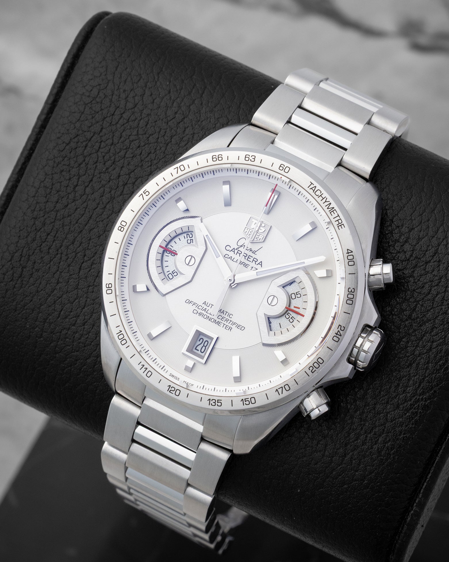 An angled studio profile shot of the 43mm stainless steel TAG Heuer Grand Carrera Calibre 17 automatic watch on a leather cushion