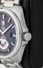 Side profile view of the brushed and polished stainless steel case and signed screw-down crown of a TAG Heuer Grand Carrera