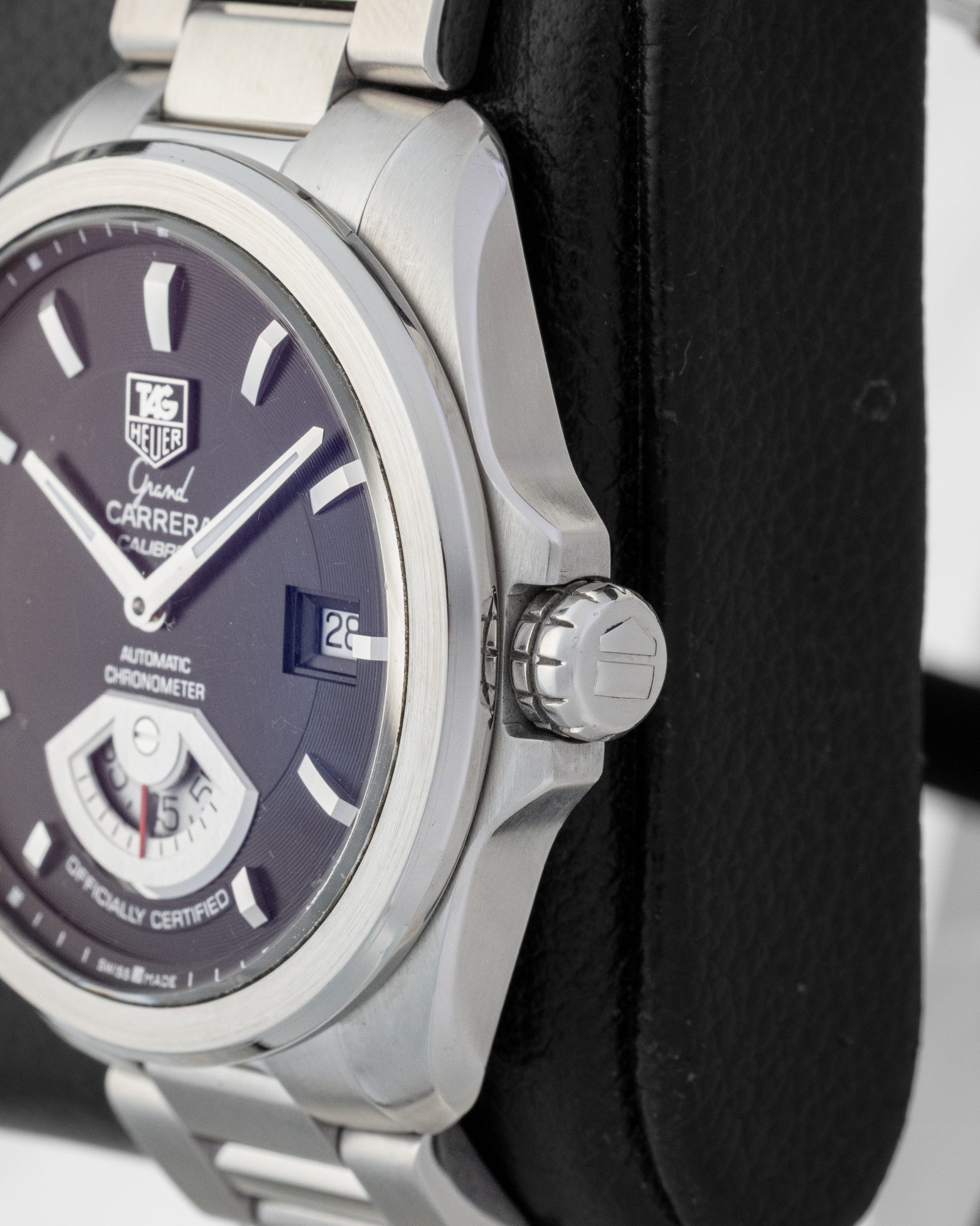 Side profile view of the brushed and polished stainless steel case and signed screw-down crown of a TAG Heuer Grand Carrera