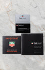 Official TAG Heuer international guarantee card displayed alongside the red registration reminder insert and black leatherette owner instruction handbook manual