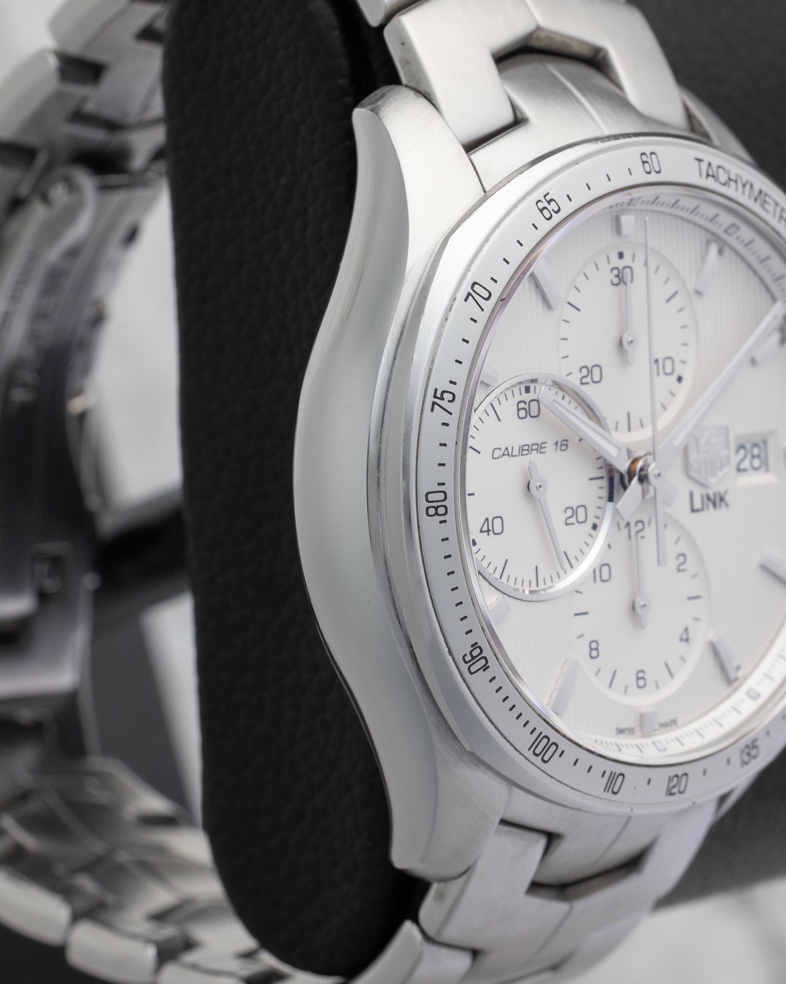 Side profile view of the polished and brushed stainless steel case on the non-crown side of a TAG Heuer Link chronograph
