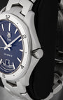 Close up right profile view of the watch head highlighting the polished fluted push-pull winding crown nestled perfectly between protective steel case shoulders
