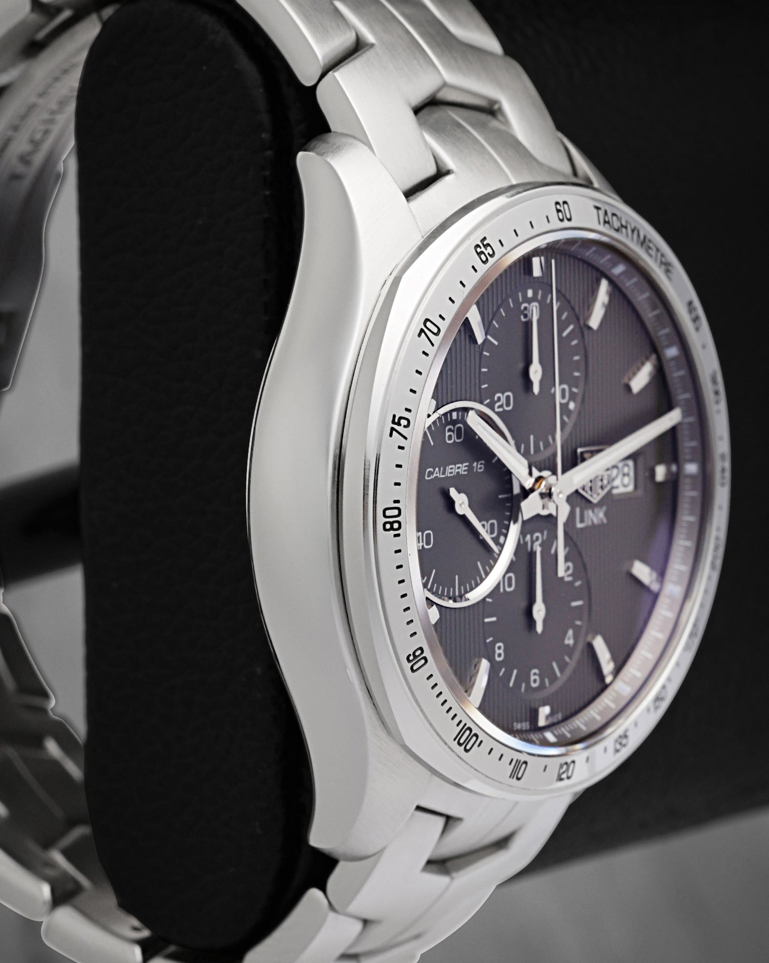 Left-side macro profile view showcasing the premium satin-brushed case wall and the clean, curved integration into the signature fluid double-S link bracelet