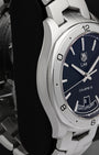 Left-side studio profile view showcasing the fine satin graining across the case wall and the seamless flow into the iconic integrated bracelet lugs