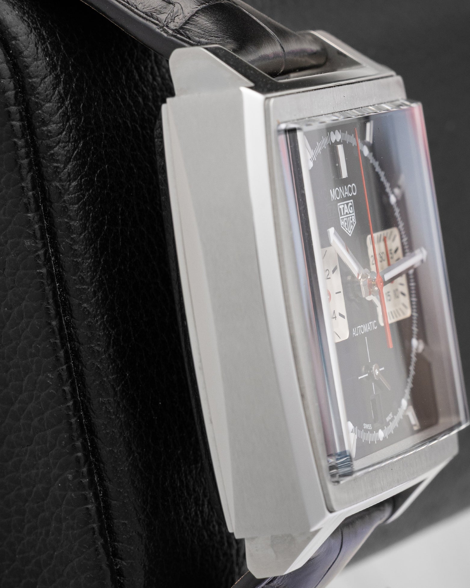 Left side profile displaying the fine-brushed and polished stainless steel case and domed sapphire crystal of TAG Heuer Monaco CBL2113
