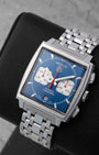 Angled front view of a preowned TAG Heuer Monaco CW2113.BA0780 featuring a classic blue dial, white square subdials, and red hands