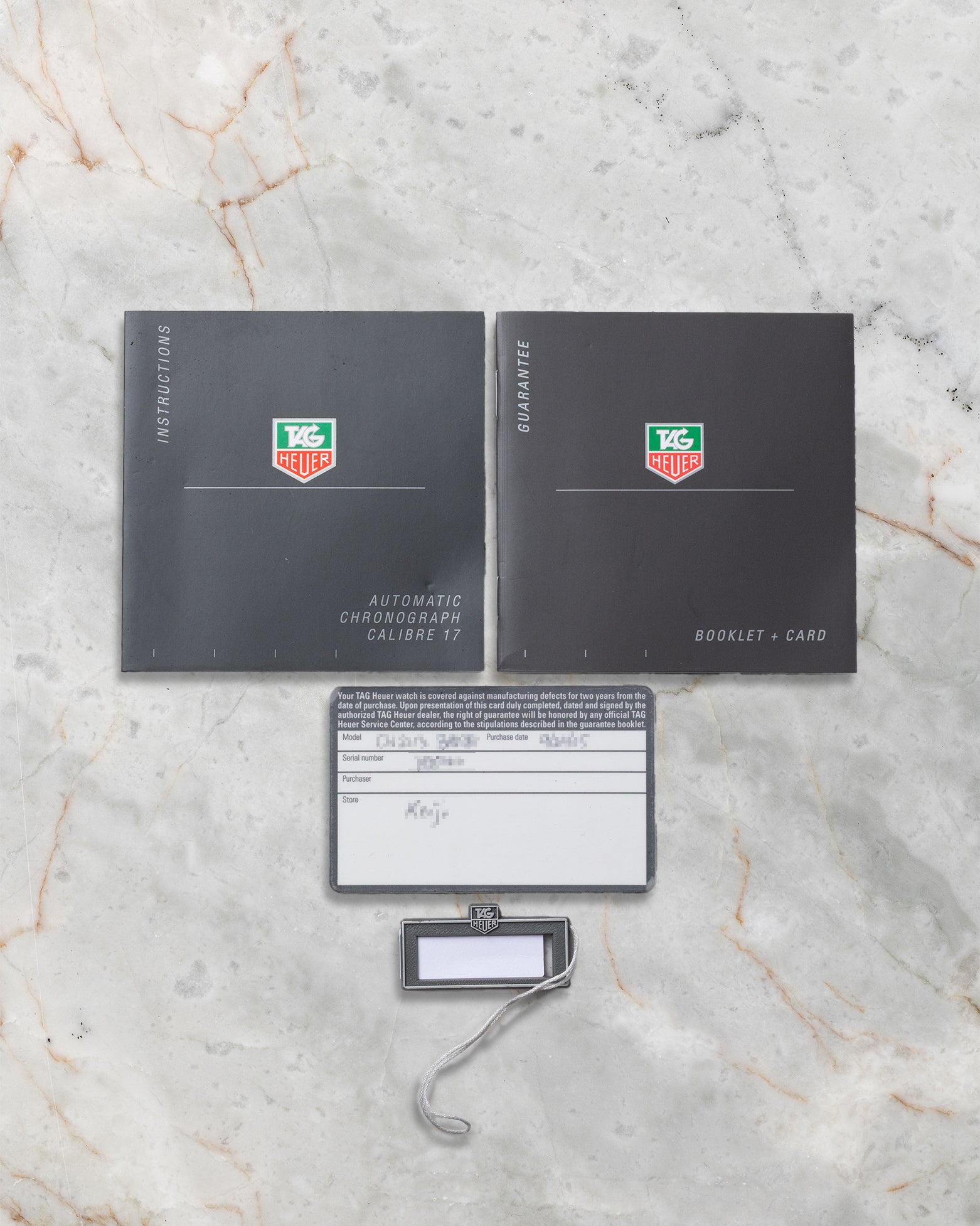 TAG Heuer Monaco CW2113 instruction booklets, guarantee card, and serial number hang tag