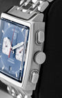 Side profile showing the square stainless steel case, signed winding crown, and rectangular chronograph pushers on a TAG Heuer Monaco CW2113