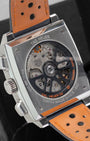 Sapphire crystal exhibition caseback displaying the in-house Heuer 02 automatic chronograph movement and orange lining of the perforated strap.