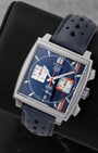 Angled perspective of a pre-owned TAG Heuer Monaco Gulf CBL2115.FC6494 showing the square 39mm stainless steel case and blue perforated calfskin racing strap.