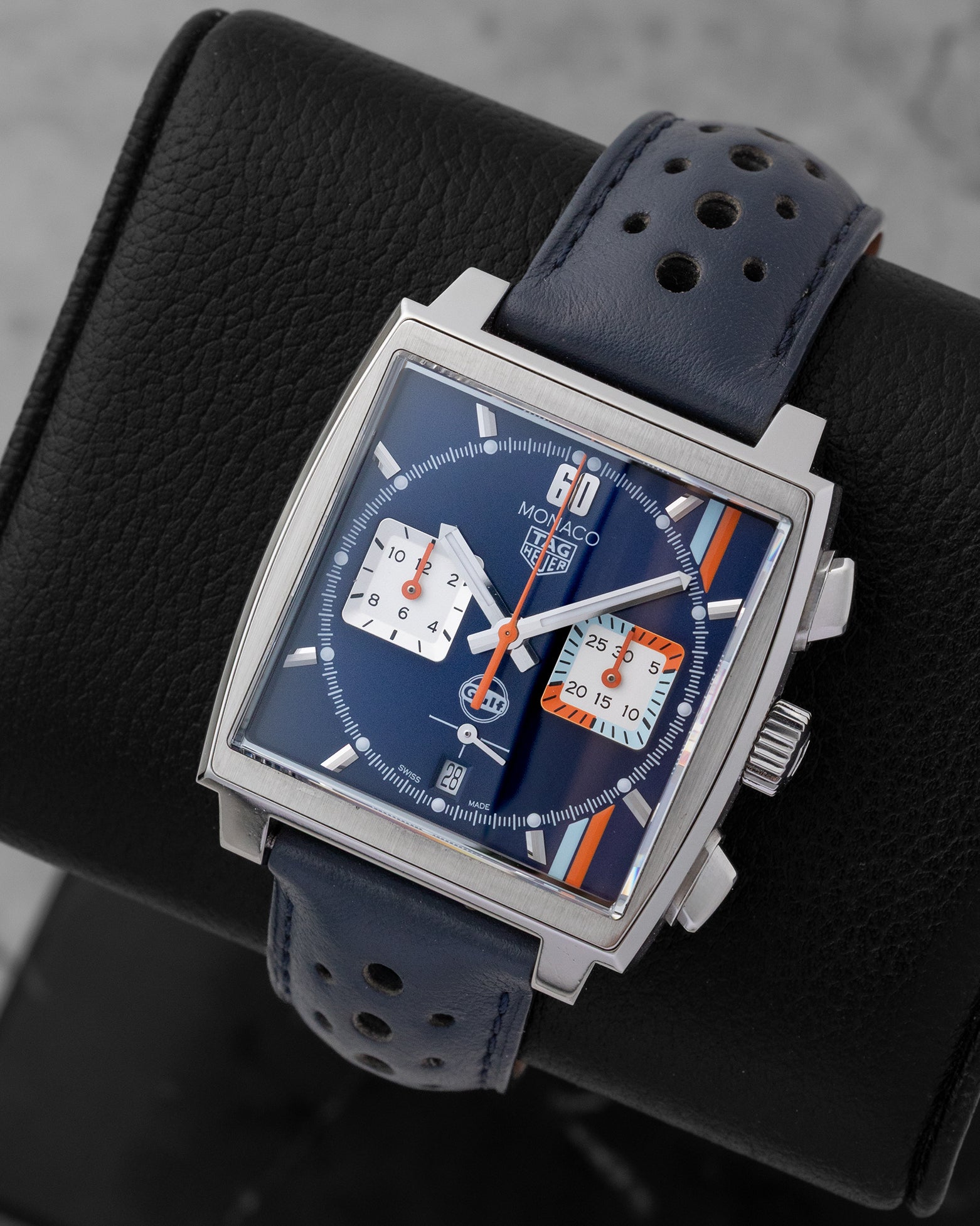 Angled perspective of a pre-owned TAG Heuer Monaco Gulf CBL2115.FC6494 showing the square 39mm stainless steel case and blue perforated calfskin racing strap.