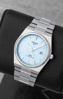 Angled view of the Tissot PRX automatic watch, showcasing the waffle texture dial and light reflecting on the baton indexes